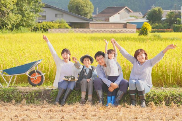 稲刈りをする家族